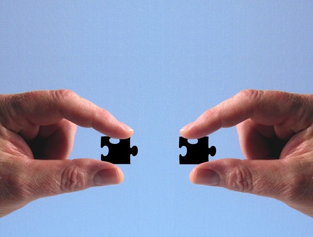 Två händer som sammanfogar pusselbitar